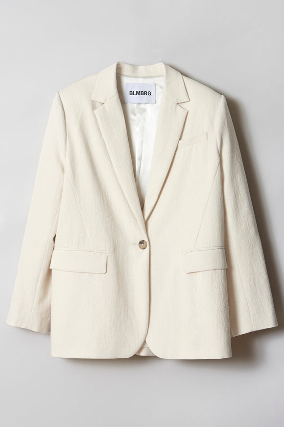 A cream-hued, single-breasted jacket made of a mid-weight fabric with a single horn button showed flat from the front.