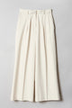 A cream-hued, wide-legged pair of trousers made of a mid-weight fabric with pleats and side slit pockets showed flat from the front.