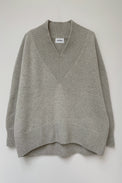 Front of a cosy v-neck cashmere sweater in light grey photographed flat.