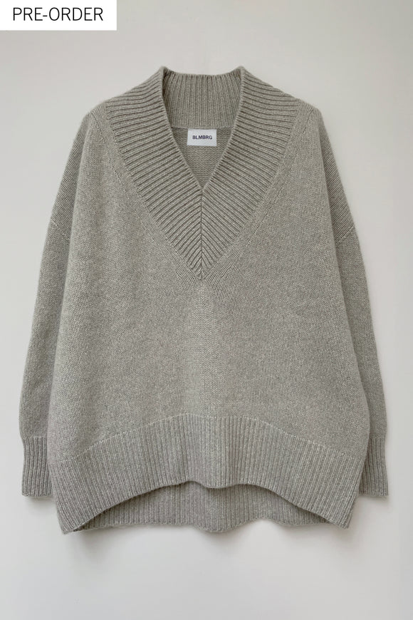 Front of a cosy v-neck cashmere sweater in light grey photographed flat.