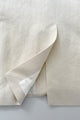 Closeup of of the back vent on a cream-hued jacket